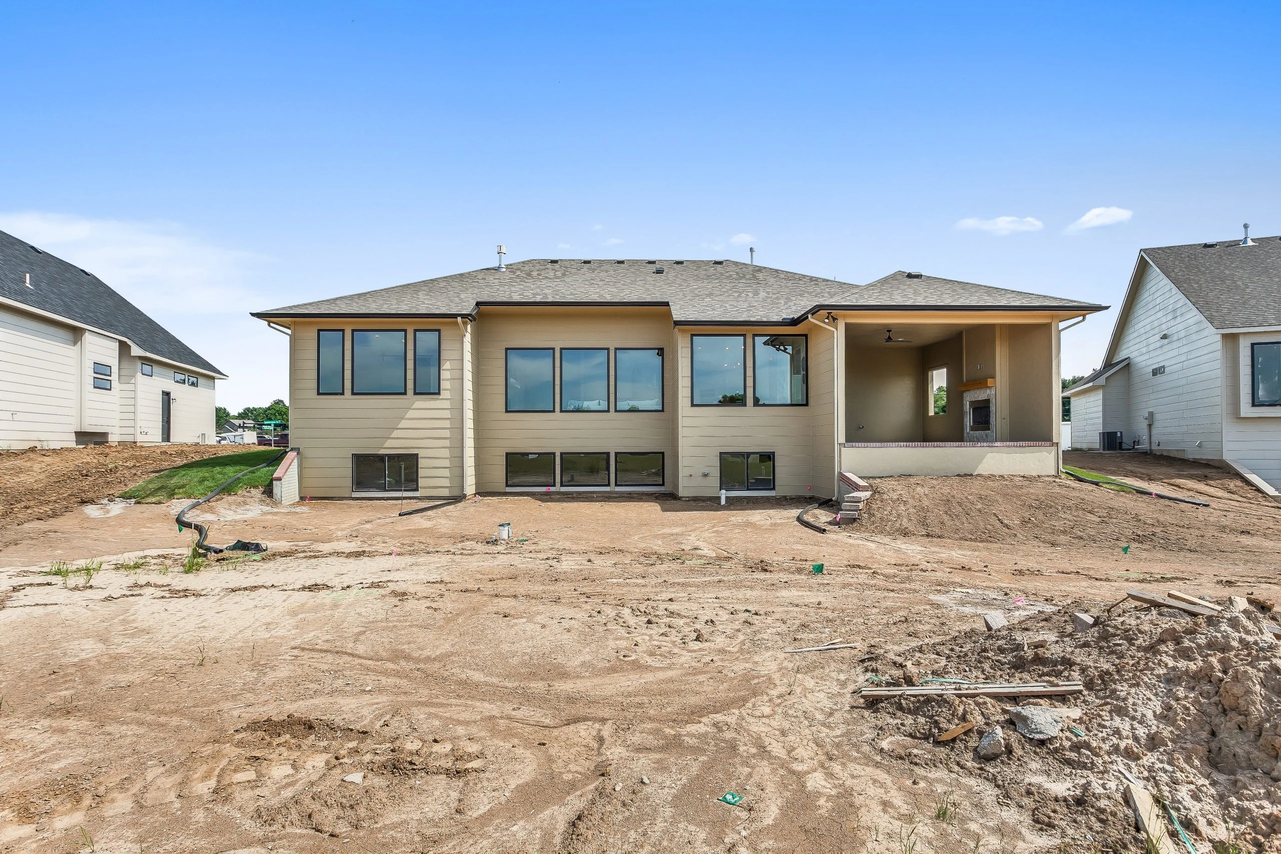 Rear of a new home before final landscaping, with the lot graded around the foundation